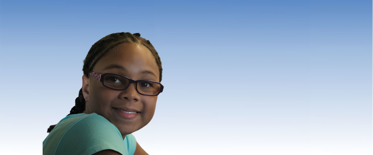 A girl smiling with glasses and a blue shirt, with a blue and white gradient background