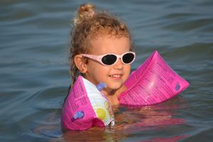 Pictured: Preschooler Vittoria “Vicky” Cerolini swimming with pink floaties and pink sunglasses. Vicky has Leber congenital amaurosis (LCA)