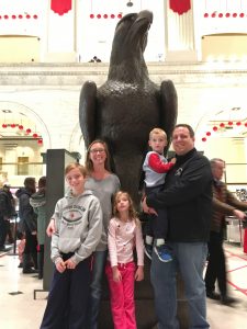 Hannah Reif, 7, will likely receive gene therapy surgery this summer to cure her vision loss caused by LCA-RPE65. Pictured: Hannah, center, with her mom Amy, dad Christopher and brothers Jacob and Matthew, standing in front of a giant bald eagle statue.
