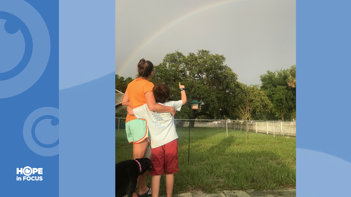 Creed and his mother pointing at the rainbow in the sky