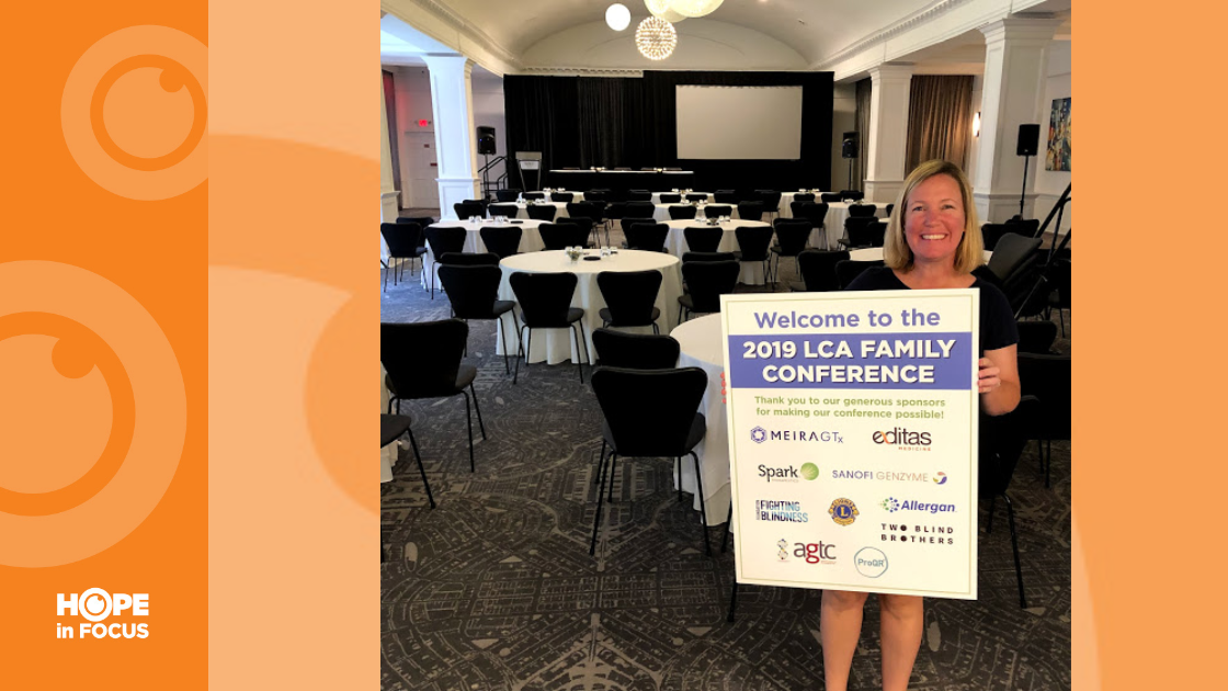 Beth B. holding up 2019 LCA Family Conference poster