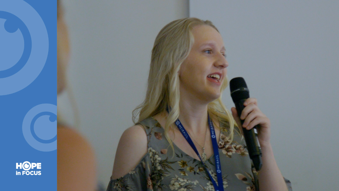 Kristen speaking into a microphone