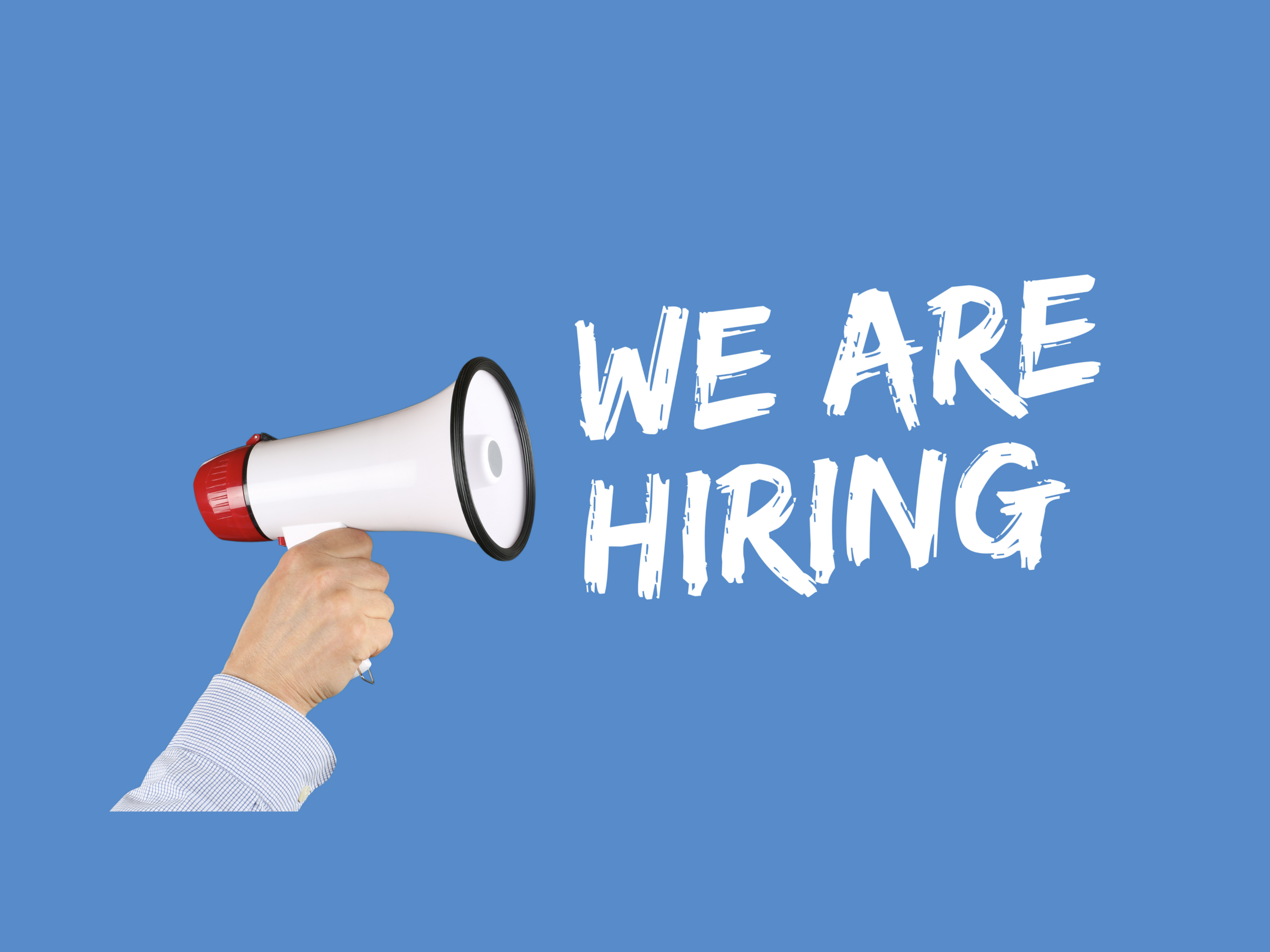 Blue background with white text saying "We are hiring" with a microphone