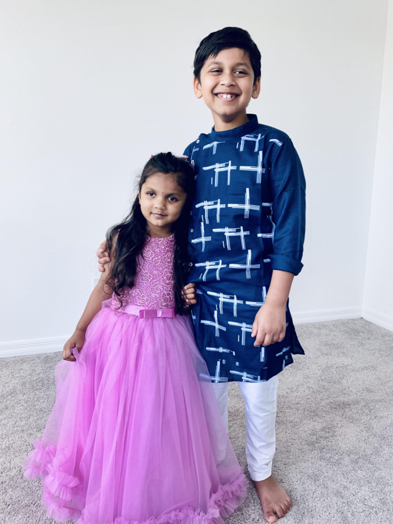 Parvi in a pink long dress with her brother, Thanmay, besides her wearing blue