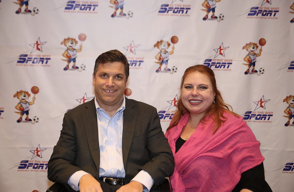 Michael wearing a gray suit and Katie next to him wearing a pink shawl. 