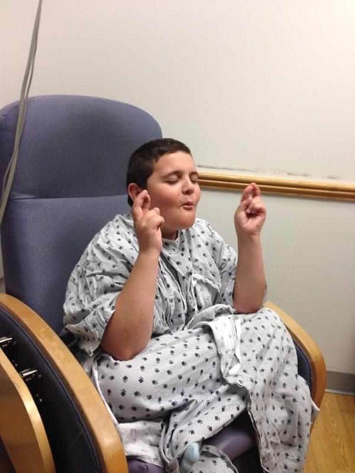 Christian in a hospital gown crossing his fingers