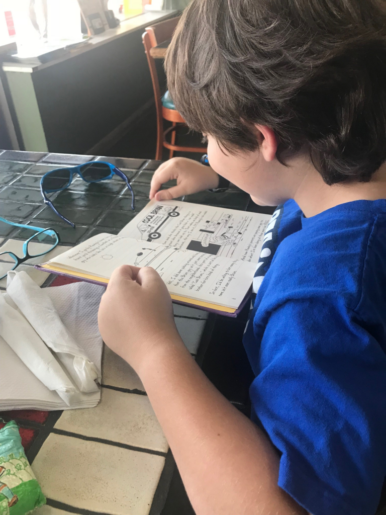Creed in a blue shirt reading a book