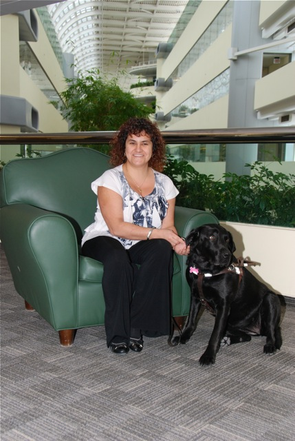 Orly sitting next to her black lab