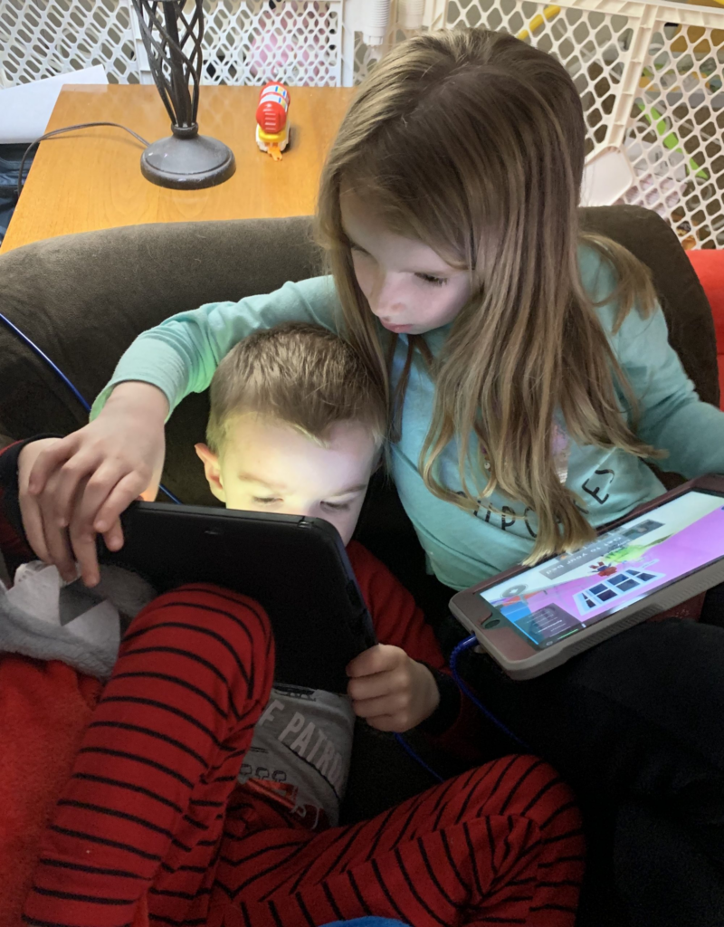 Anna helping Drew on his ipad