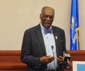 James Rawlings speaking on podium. 