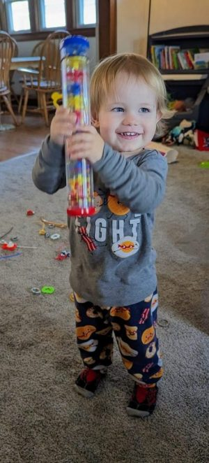 Atlas in pajamas and shaking a toy