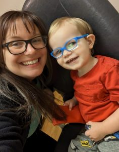 Jessi (L) and Atlas (R) both wearing glasses and smiling.