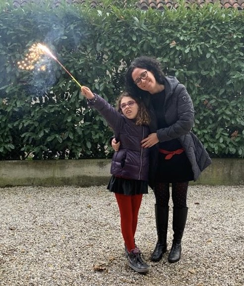 Vicky (L) holding a sparkler and Silvia (R) hugging Vicky.