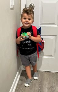 Jace with his red backpack and toy car